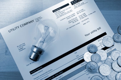 energy bill with a lightbulb and change on top of it